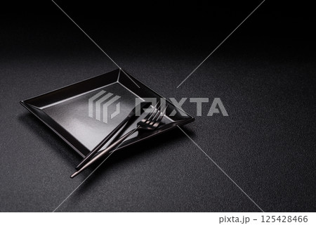 Empty ceramic round plate on dark textured concrete background Empty ceramic round plate on dark textured concrete background 125428466