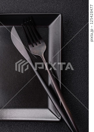 Empty ceramic round plate on dark textured concrete background Empty ceramic round plate on dark textured concrete background 125428477