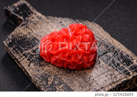 Red wax candle in the shape of a heart as decor for Valentine's Day 125428805