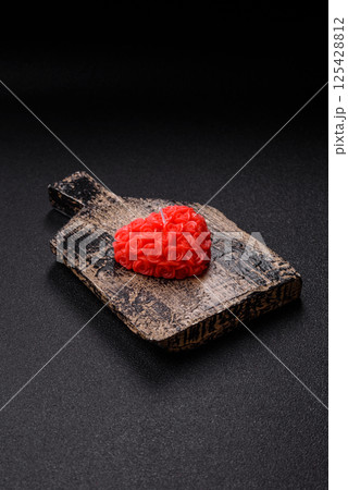 Red wax candle in the shape of a heart as decor for Valentine's Day 125428812