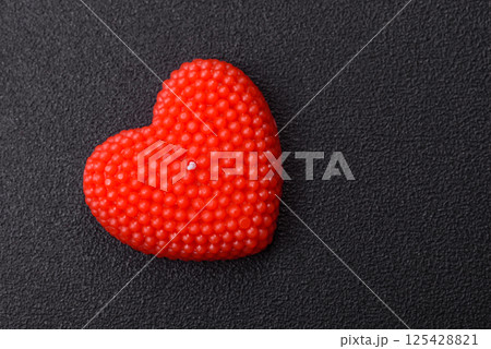 Red wax candle in the shape of a heart as decor for Valentine's Day Red wax candle in the shape of a heart as decor for Valentine's Day 125428821