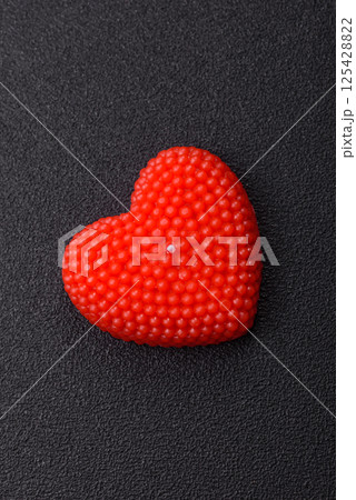 Red wax candle in the shape of a heart as decor for Valentine's Day Red wax candle in the shape of a heart as decor for Valentine's Day 125428822