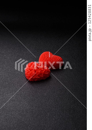 Red wax candle in the shape of a heart as decor for Valentine's Day 125428831