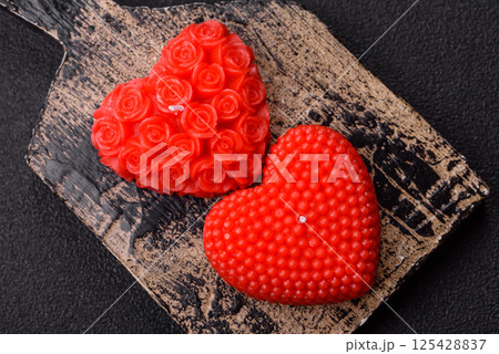Red wax candle in the shape of a heart as decor for Valentine's Day Red wax candle in the shape of a heart as decor for Valentine's Day 125428837