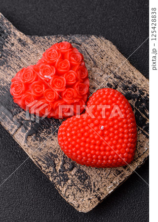 Red wax candle in the shape of a heart as decor for Valentine's Day 125428838