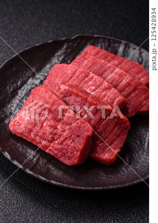Raw beef tenderloin cut into slices with salt and spices 125428934