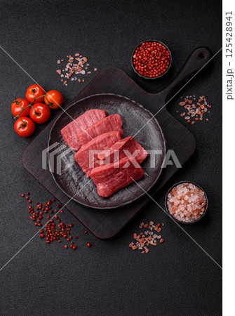 Raw beef tenderloin cut into slices with salt and spices 125428941