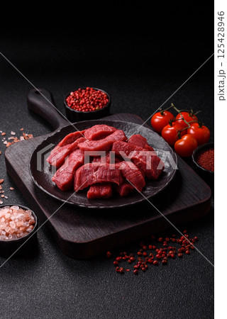 Raw beef tenderloin cut into slices with salt and spices 125428946