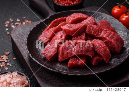 Raw beef tenderloin cut into slices with salt and spices 125428947