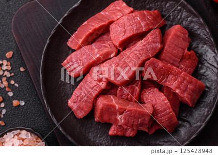 Raw beef tenderloin cut into slices with salt and spices 125428948