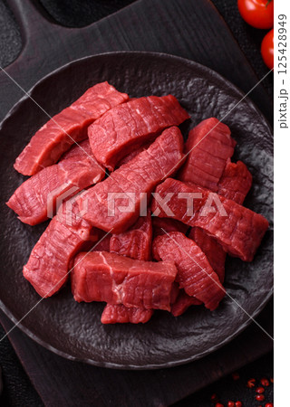 Raw beef tenderloin cut into slices with salt and spices 125428949