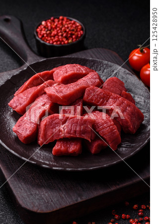 Raw beef tenderloin cut into slices with salt and spices Raw beef tenderloin cut into slices with salt and spices 125428950