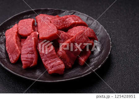 Raw beef tenderloin cut into slices with salt and spices Raw beef tenderloin cut into slices with salt and spices 125428951