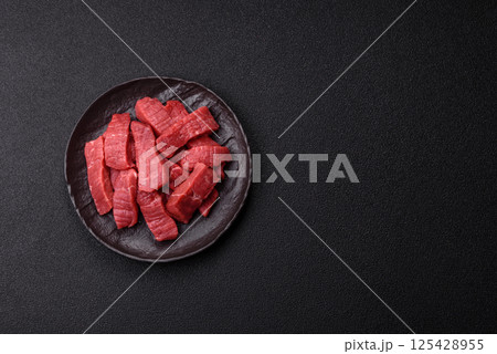 Raw beef tenderloin cut into slices with salt and spices 125428955