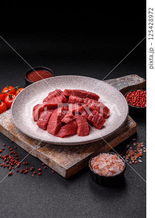 Raw beef tenderloin cut into slices with salt and spices Raw beef tenderloin cut into slices with salt and spices 125428972