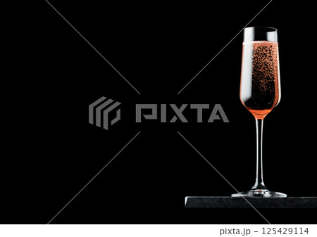 Elegant glass of pink rose champagne with bubbles on blavk marble board on black background. Elegant glass of pink rose champagne with bubbles on blavk marble board on black background. 125429114