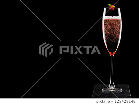 Elegant glass of pink rose champagne with raspberry on stick on black marble board on black Elegant glass of pink rose champagne with raspberry on stick on black marble board on black 125429149
