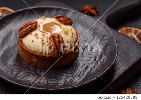 Sweet round tart with white citrus cream and pecans Sweet round tart with white citrus cream and pecans 125429399