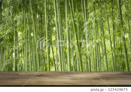 Bamboo forest table. Empty wooden table for product display on green bamboo forest background 125429673