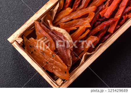 Jerky, dried fish in the form of sticks with salt, spices and herbs 125429689