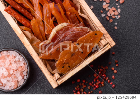 Jerky, dried fish in the form of sticks with salt, spices and herbs 125429694