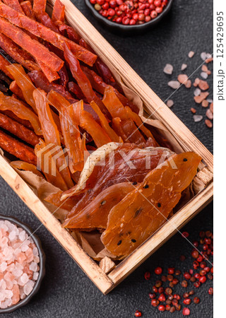 Jerky, dried fish in the form of sticks with salt, spices and herbs 125429695