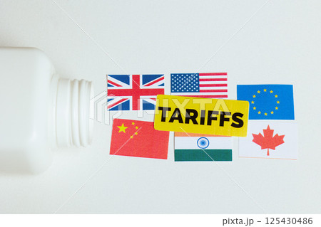 Pill bottle labeled TARIFFS next to six global flags Pill bottle labeled TARIFFS next to six global flags 125430486