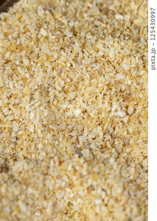 dried garlic for cooking closeup, dried spices from very small pieces of garlic fruits, dehydrated 125430997