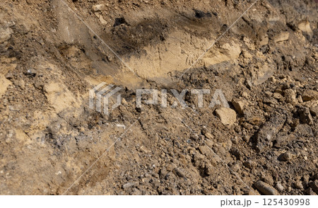 the end of summer at the construction site, dry sand and earth in sunny weather, side view the end of summer at the construction site, dry sand and earth in sunny weather, side view 125430998
