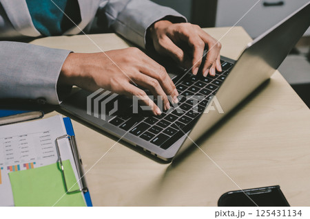 Working from home, Closeup business woman using laptop computer and analyzing financial report. Working from home, Closeup business woman using laptop computer and analyzing financial report. 125431134