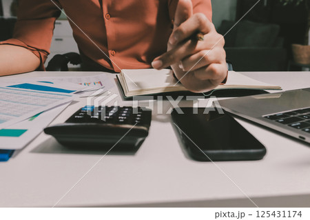 Working from home, Closeup business woman using laptop computer and analyzing financial report. Working from home, Closeup business woman using laptop computer and analyzing financial report. 125431174