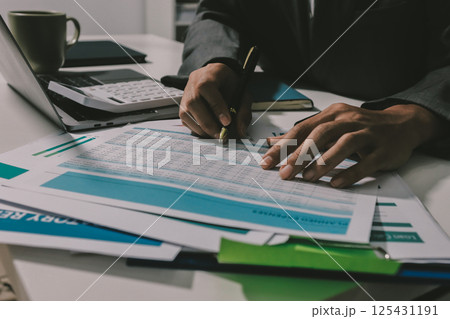 Working from home, Closeup business woman using laptop computer and analyzing financial report. Working from home, Closeup business woman using laptop computer and analyzing financial report. 125431191