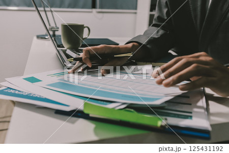 Working from home, Closeup business woman using laptop computer and analyzing financial report. Working from home, Closeup business woman using laptop computer and analyzing financial report. 125431192