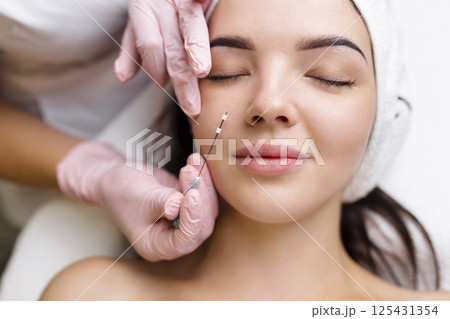 Face lifting PDO Suture operation. innovative technique of New thread lift, cosmetologist preparing to do procedure to female client, select the appropriate thread option 125431354