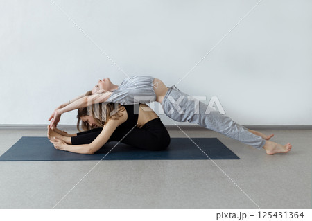 sporty yogi sisters doing fitness training. pair, couple yoga sporty yogi sisters doing fitness training. pair, couple yoga 125431364