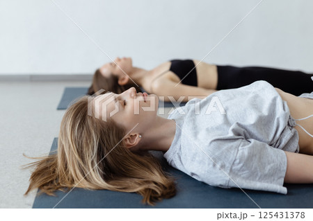Fitness group doing practicing in a yoga class. Shavasana or corps pose, yoga practice 125431378