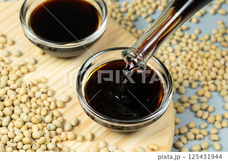 Stream of Soy Sauce Filling a Sauce Dish Stream of Soy Sauce Filling a Sauce Dish 125431944