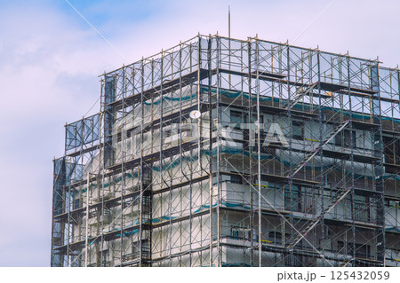 日本の横浜都市景観　マンションの補修や点検等、足場や防護ネットなど。ネットの外に衛星アンテナが… 125432059