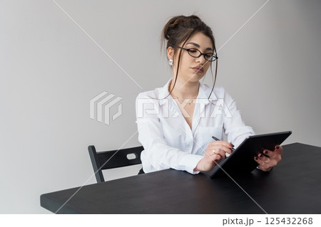 Young Woman Working on Tablet in a Professional Setting 125432268