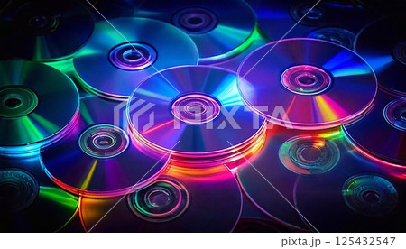 A collection of compact discs showcasing vivid neon reflections in a dark setting 125432547