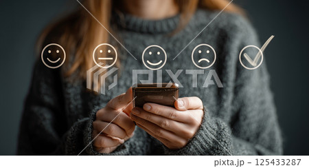 person using smartphone to complete online survey with emoticon options 125433287