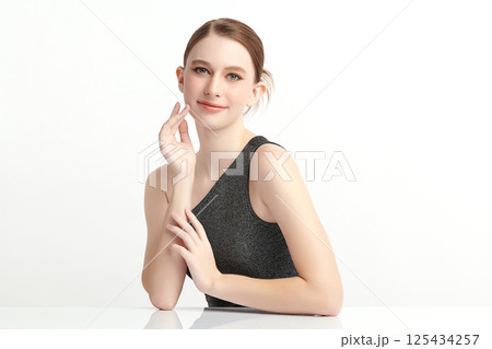 A beautiful young woman with clean, fresh skin against a white background. Skincare, facial treatment, cosmetology, beauty, and spa. An elegant portrait of an woman. 125434257
