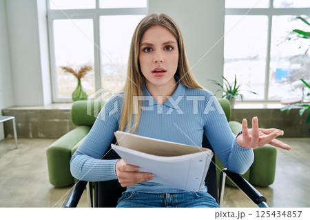 Webcam view young female student with textbook in hands, sitting at home Webcam view young female student with textbook in hands, sitting at home 125434857