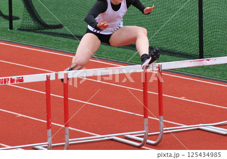 One Girl Running in a Track Hurdle Race One Girl Running in a Track Hurdle Race 125434985