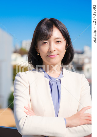 青空の下白いスーツ姿で自信あふれるミドルキャリアウーマン 青空の下白いスーツ姿で自信あふれるミドルキャリアウーマン 125435092