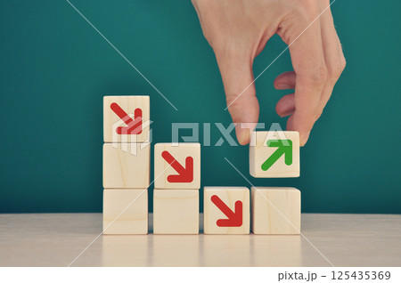 Businessman stacking wooden blocks into growing successful financial char Businessman stacking wooden blocks into growing successful financial char 125435369