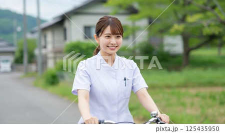 農村を自転車で巡回する地域の若手看護師 農村を自転車で巡回する地域の若手看護師 125435950