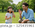 公園でシャボン玉遊びを楽しむ父娘・週末ファミリータイム 125435961