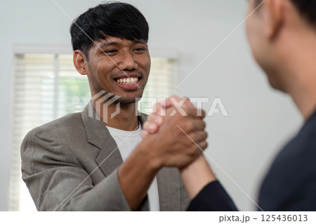 Business Meeting and Collaboration. Two professionals engaging in a handshake to signify partnership. 125436013
