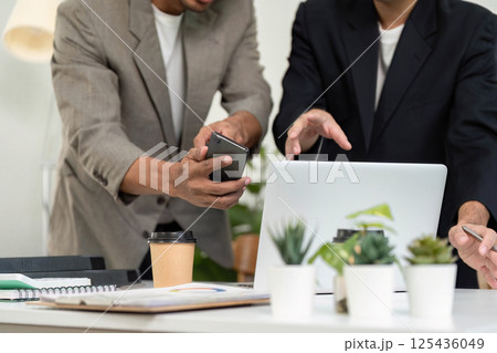 Smartphone and Collaboration. Two men discussing ideas while using a smartphone and laptop. Smartphone and Collaboration. Two men discussing ideas while using a smartphone and laptop. 125436049